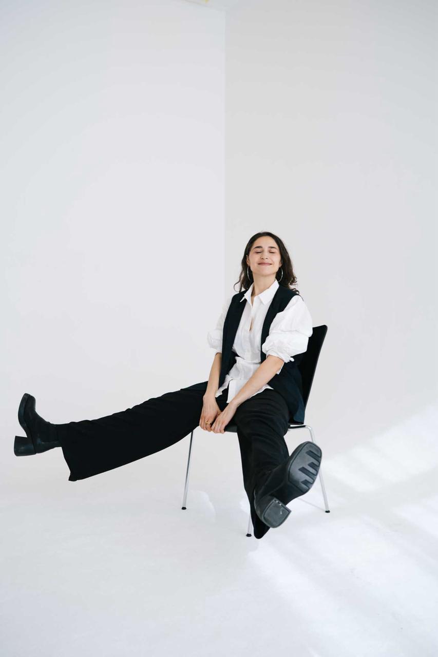 Alena Margarita Kroker seated in a white shirt and black vest